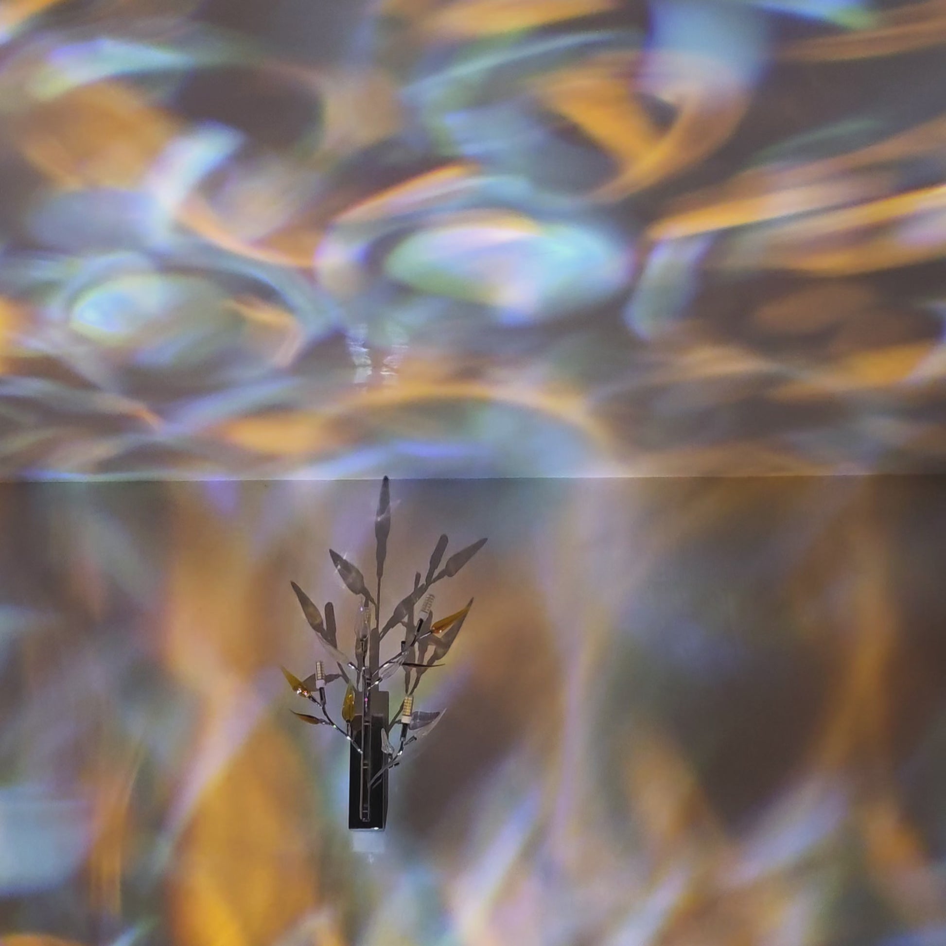 Relaxing ambient water ripple light projection moving across wall and ceiling with blue and gold reflections.