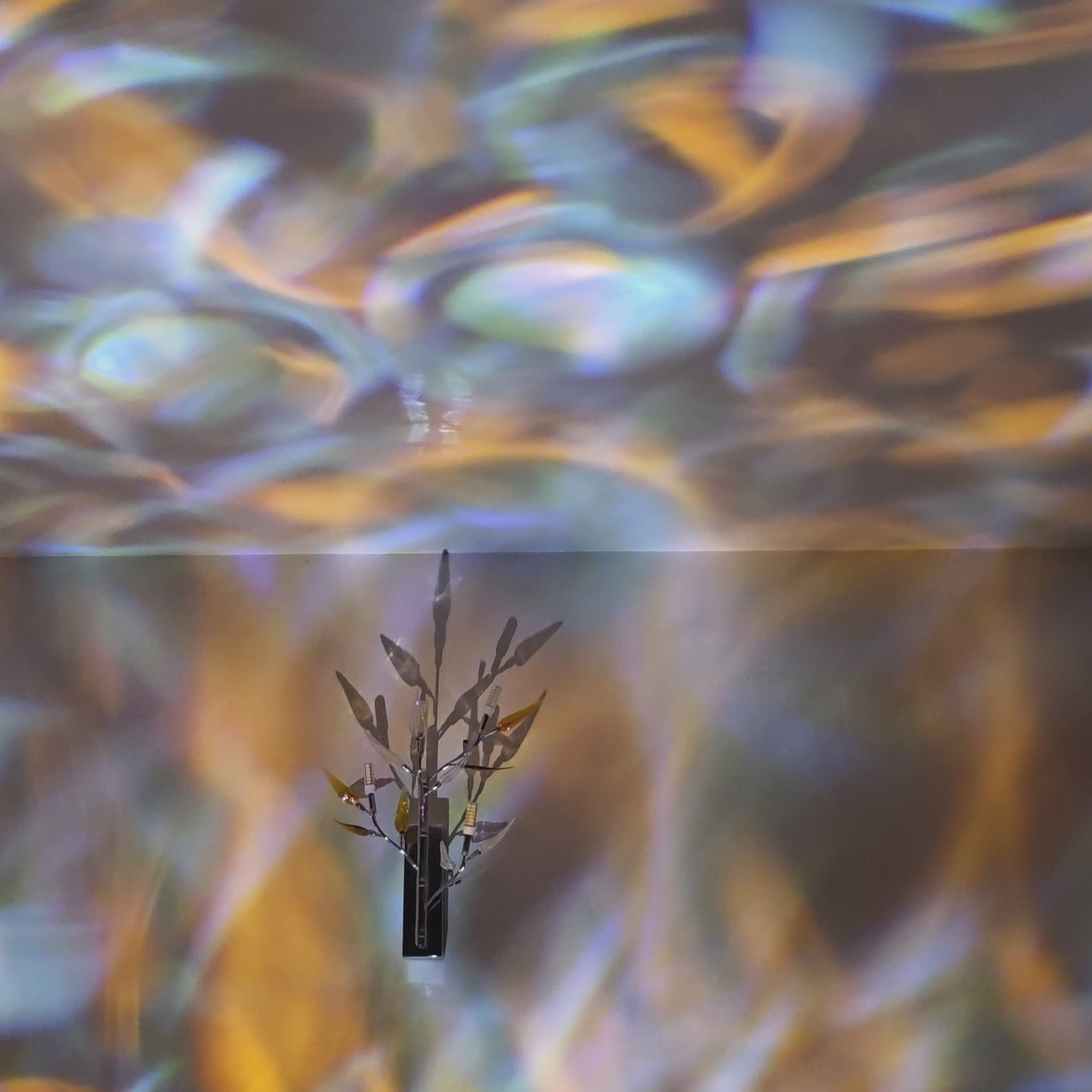 Relaxing ambient water ripple light projection moving across wall and ceiling with blue and gold reflections.